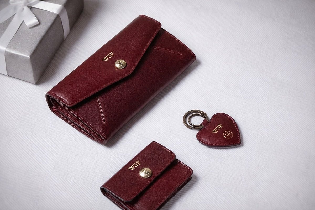 Leather cardholder and key fob arranged on white background with embossing leather details